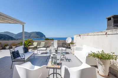 a patio with white chairs and tables on a roof at Casa Annibale con Vista Mare by Wonderful Italy in Palermo