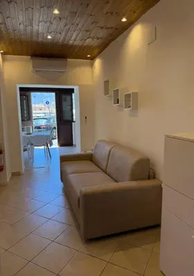 a living room with a couch and a table at DomusSolis - Casa vacanza a 2 passi dal mare in Palermo