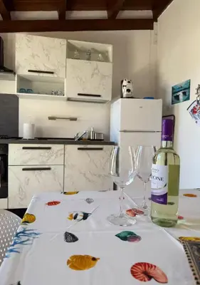 a table with a bottle of wine and two glasses at DomusSolis - Casa vacanza a 2 passi dal mare in Palermo