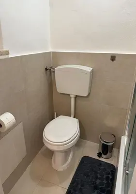 a small bathroom with a toilet and a black rug at DomusSolis - Casa vacanza a 2 passi dal mare in Palermo