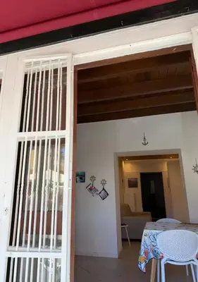 a room with a door and a table and a table and chairs at DomusSolis - Casa vacanza a 2 passi dal mare in Palermo
