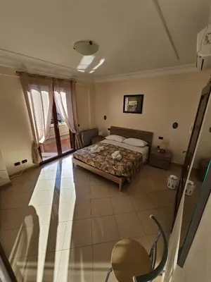a bedroom with a bed and a chair in it at Villa Nino in Palermo