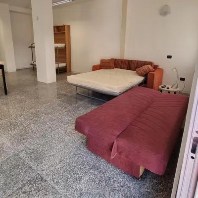 a bed sitting in a room with a couch at Il Loft di Godrano in Godrano