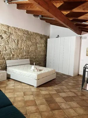a bedroom with a bed and a stone wall at Casa Vacanza 