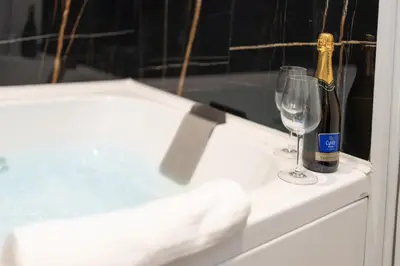 a bottle of champagne and a wine glass on a counter at Le suite di Alba in Palermo