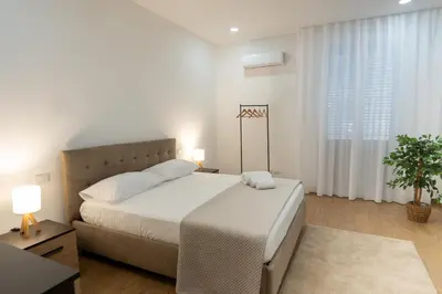 a white bedroom with a large bed and a window at Home1995 in Palermo