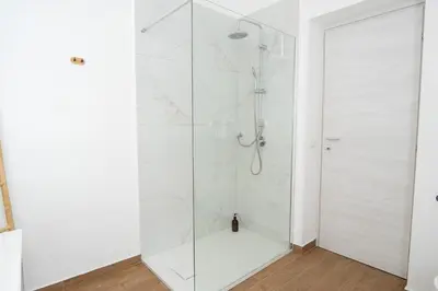 a white shower with a glass door in a bathroom at Home1995 in Palermo