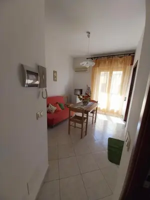 a living room with a red couch and a table at Caterina in Isola delle Femmine