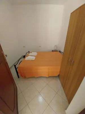 a bedroom with a wooden bed and a wooden door at Caterina in Isola delle Femmine