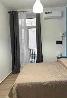 a bedroom with a bed and a large window at Orologio21-Soggiorna al teatro Massimo in Palermo