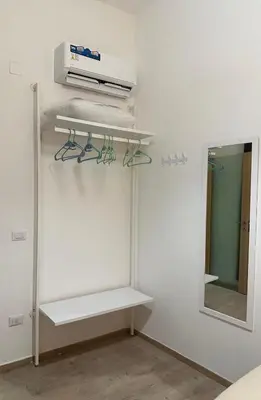 a white room with a shelf and a mirror at Orologio21-Soggiorna al teatro Massimo in Palermo