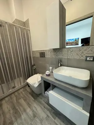 a bathroom with a sink and a toilet and a mirror at Blue Wave Apartment in Palermo