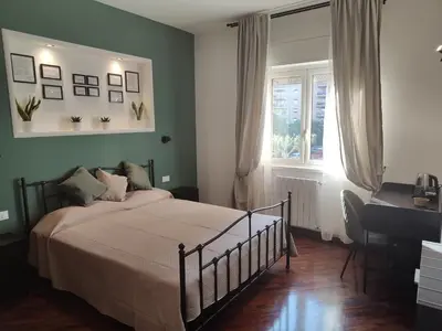 a bedroom with a bed and a desk and a window at Quintadecima Rooms in Palermo