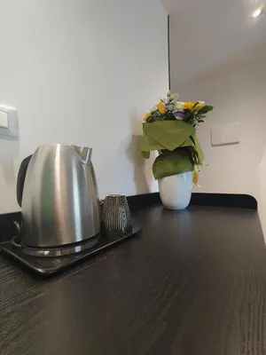a tea kettle and a vase of flowers on a table at Quintadecima Rooms in Palermo