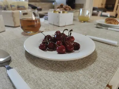 a plate of cherries on top of a table at Quintadecima Rooms in Palermo