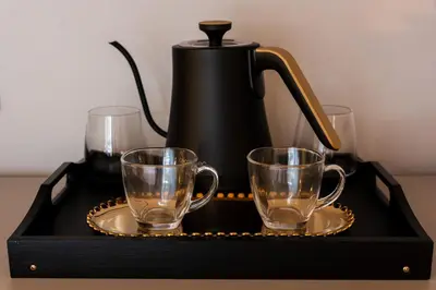 a black tea kettle and two glasses on a tray at Chiave di Volta luxury suite e rooms in Palermo