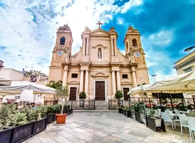 an old church with two towers and chairs in front of it at Casa Sciàpó in Terrasini