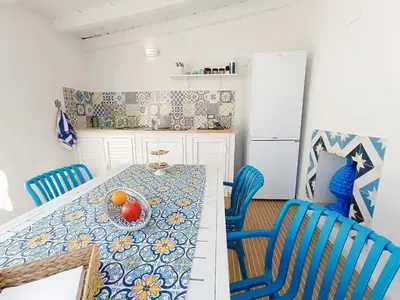 a kitchen with a table with a bowl of fruit on it at Casa Sciàpó in Terrasini