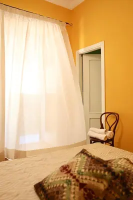 a bedroom with a bed with a white curtain and a window at Maria's apartment alla Magione, appartamento in centro in Palermo
