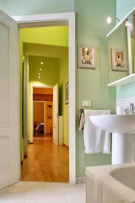 a bathroom with a white sink and green walls at Maria's apartment alla Magione, appartamento in centro in Palermo