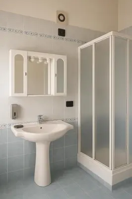 a white bathroom with a sink and a shower at SetteDì Apartment in Palermo
