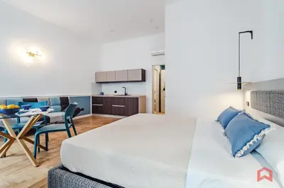 a bedroom with a king sized bed and a kitchen at Nuovissimo Appartamento nel Cuore di Palermo in Palermo