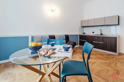 a dining room with a glass table and blue chairs at Nuovissimo Appartamento nel Cuore di Palermo in Palermo
