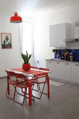 a kitchen with a table and two chairs and a plant at Appartamenti Marì 1 in Palermo