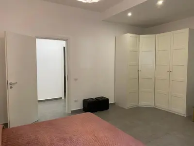 a bedroom with white cabinets and a bed with a suitcase at Appartamenti Mari' 2 in Palermo