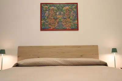 a bedroom with a bed with a picture on the wall at Appartamenti Mari' 2 in Palermo