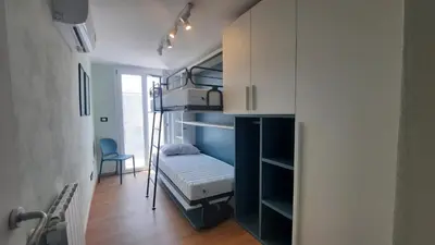 a small room with a bunk bed and a room with a chair at Oltre i Canti in Palermo
