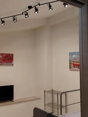 a living room with a tv and lights on the wall at Casa dalla Zia Maria in Capaci