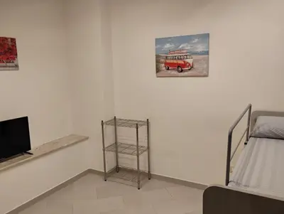 a white room with a bed and a tv and a room with a bed gmaxwell at Casa dalla Zia Maria in Capaci