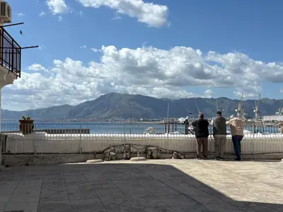 three people standing on a wall looking at the water at Casa Ciccina in Palermo