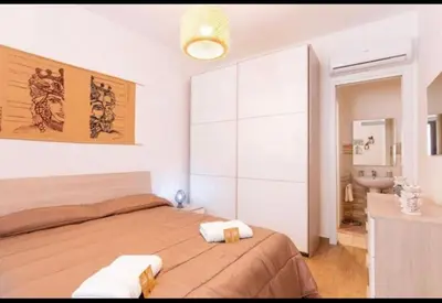 a bedroom with a large bed and a bathroom at La casetta di Andrea in Palermo