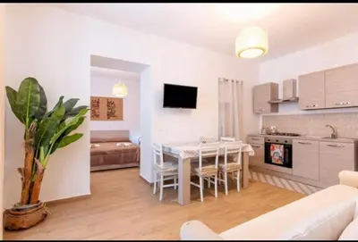 a kitchen and living room with a table and a couch at La casetta di Andrea in Palermo