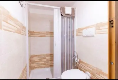 a small bathroom with a toilet and a shower at La casetta di Andrea in Palermo