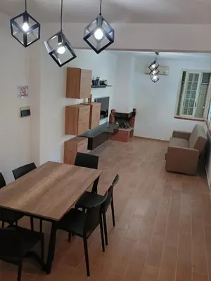 a dining room and living room with a table and chairs at Il Giardino di Lia in Palermo