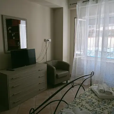 a bedroom with a tv and a chair and a dresser at Stella del mare in Palermo