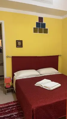 a bedroom with a red bed with towels on it at Monolocale Signorile in Castellammare del Golfo