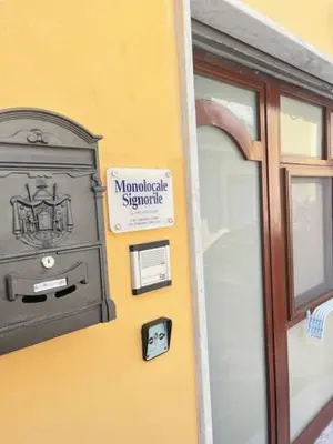 a building with a sign on the side of it at Monolocale Signorile in Castellammare del Golfo