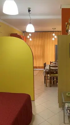 a dining room with a table and a yellow wall at Monolocale Signorile in Castellammare del Golfo