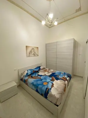 a bedroom with a bed with a blue and white comforter at Corso Butera 489 in Bagheria