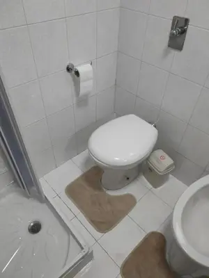 a white bathroom with a toilet and a sink at Corso Butera 489 in Bagheria