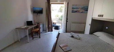 a bedroom with a bed and a desk with a computer at House Calamigna in Ventimiglia di Sicilia