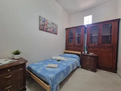 a bedroom with a bed and a wooden cabinet at House Calamigna in Ventimiglia di Sicilia