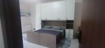 a bedroom with a bed and white cabinets at House Calamigna in Ventimiglia di Sicilia
