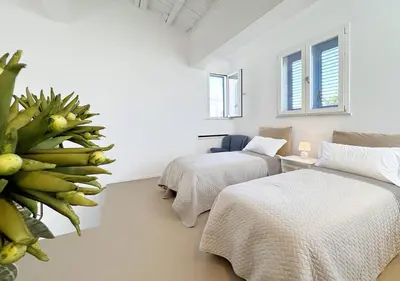 a room with two beds and a plant at Solemar Sicilia - Villa Regina Elena in Palermo