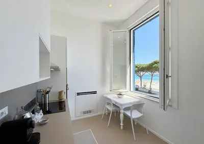 a kitchen with a table and a window with a view of the beach at Solemar Sicilia - Villa Regina Elena in Palermo
