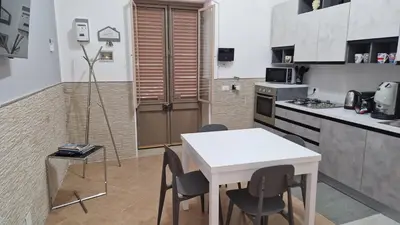 a kitchen with a white table and chairs in it at The brothers house appartamento alla Zisa in Palermo